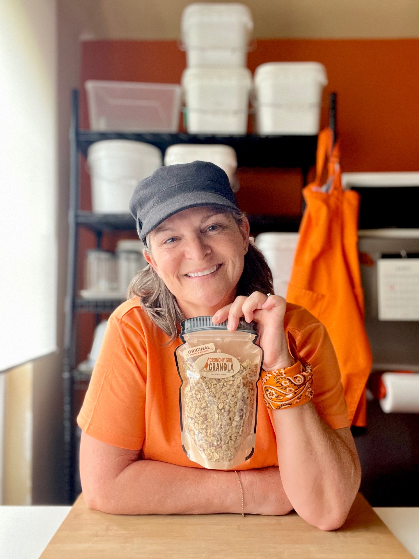 Gina holding a bag of Crunchy Girl Granola in the kitchen